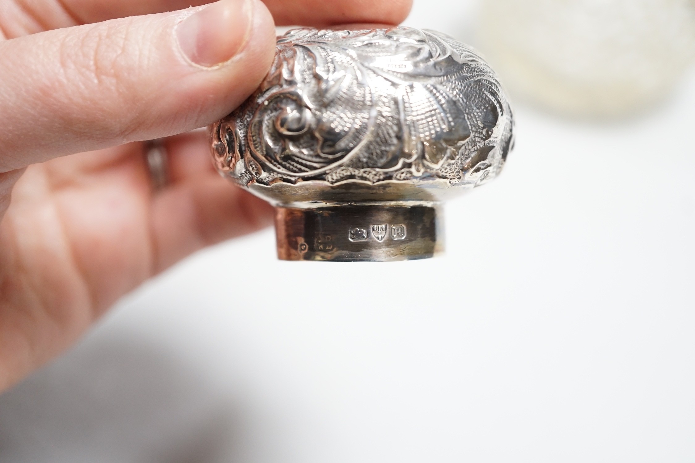 A late Victorian repousse silver mounted cut glass scent bottle, Chester, 1900, 13cm and a silver mounted sugar caster.